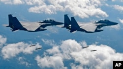 FILE - In this photo provided by South Korea Defense Ministry, South Korean air force F-15K fighter jets drop bombs as they fly over the Korean Peninsula during a joint drills with the U.S., Sept. 18, 2017. On Thursday, the air force said one of its F-15K jets crashed at a mountain in the country's rural south.