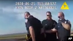 FILE - In this photo taken from police body cam video, New York Police officers, including officer David Afanador, right, arrest a man on a boardwalk in New York's Rockaway Beach, June 21, 2020. 