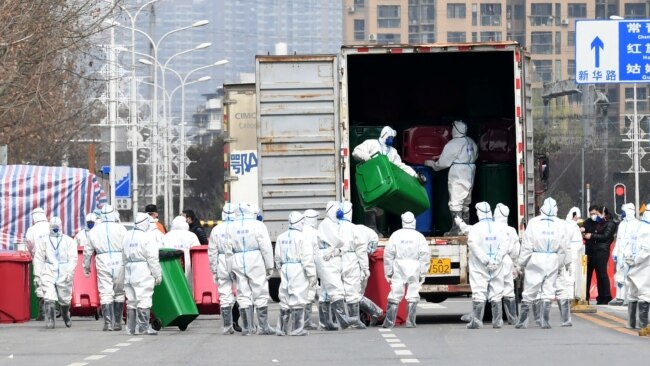 身穿防护服的工人在清理清理武汉华南海鲜市场。这里曾被认为是新冠病毒的发源地。（2020年3月4日）