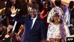 Le président sortant Macky Sall (à gauche) et son épouse Marieme Faye Sall (à droite) saluent les spectateurs à la cérémonie de son investiture comme candidat à la prochaine élection présidentielle, à Dakar, le 1er décembre 2018,