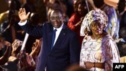 Le président sortant Macky Sall (à gauche) et son épouse Marieme Faye Sall (à droite) saluent les spectateurs à la cérémonie de son investiture comme candidat à la prochaine élection présidentielle, à Dakar, le 1er décembre 2018,