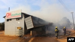 FILE: Firefighters extinguish a fire at a supermarket in Manzini, Eswatini, on June 30, 2021. (Photo by - / AFP)