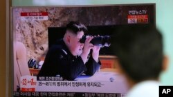 A man watches a TV screen showing a local news program reporting about North Korea's missile firing with an image of North Korean leader Kim Jong Un with a pair of binoculars, at Seoul Train Station in Seoul, South Korea, July 5, 2017.
