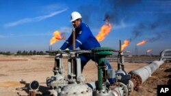 En esta foto de archivo del 12 de enero de 2017, un trabajador iraquí opera válvulas en el campo de Nihran Bin Omar, al norte de Basora, a 550 kilómetros al sudeste de Bagdad, Irak. 