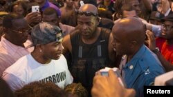 Le rappeur Nelly, à gauche, discute avec un capitaine de la police de patrouille routière à Ferguson, Missouri, 18 août 2014. 