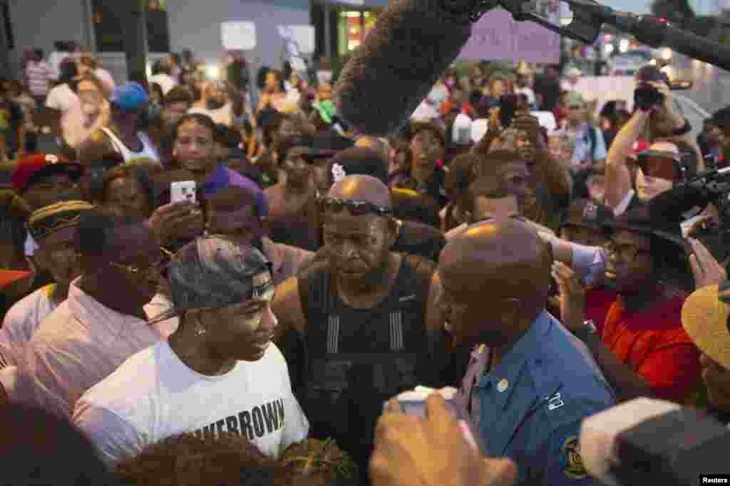 Missouri State Highway Patrol Captain Ron Johnson (center R) greets rapper Nelly on West Florissant during ongoing protests in reaction to the shooting of teenager Michael Brown in Ferguson, Missouri, Aug. 18, 2014.