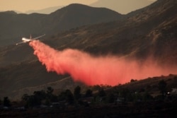 An air tanker drops retardant at a wildfire burns at a hillside in Yucaipa, Calif., Saturday, Sept. 5, 2020.