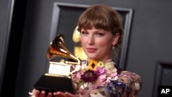 Taylor Swift berpose dengan pialanya di ruang pers ajang tahunan penghargaan musik "Grammy Award" ke-63 di Los Angeles Convention Center, 14 Maret 2021.