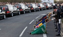 FILE - The repatriation cortege carrying the bodies of six British Army soldiers killed in Afghanistan stops at The Memorial Garden in Carterton, near Brize Norton, southern England, March 20, 2012.