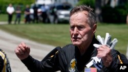 El expresidente George H. W. Bush conversa con reporteros luego de saltar en paracaídas con el equipo de los Caballeros Dorados cuando celebró sus 85 años. Junio 12, de 2009. Kennebunkport, Maine. (AP Photo/Robert F. Bukaty)