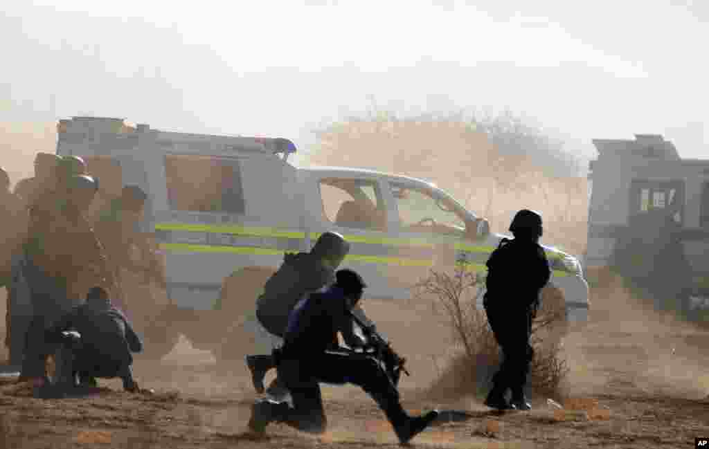 Policemen in teargas and dust open fire on striking miners at the Lonmin Platinum Mine near Rustenburg, South Africa, August 16, 2012.