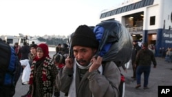 FILE - Migrants arrive at the Greek port of Piraeus, near Athens, in December. A new security report says that, since May, 43 suspected jihadists have been caught entering Europe disguised as refugees. 