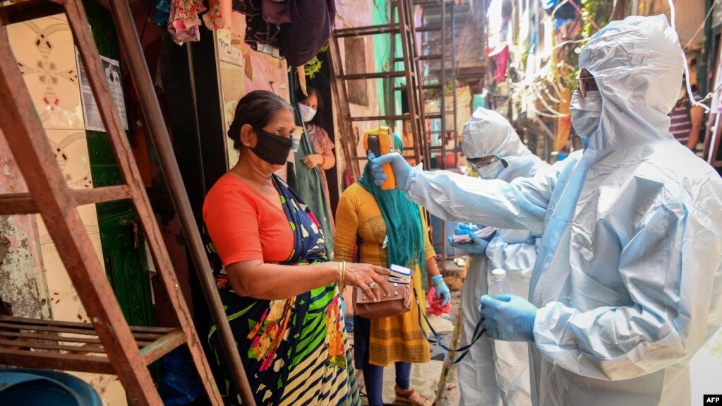 In this picture taken on June 24, 2020, medical staff wearing personal protective equipment (PPE) conduct a door-to-door medical screening inside the Dharavi slums to fight against the spread of the COVID-19 coronavirus in Mumbai. 