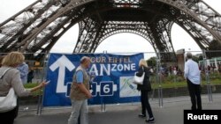 Tourists walk near the Eiffel Tower in Paris, France, June 28, 2016. 