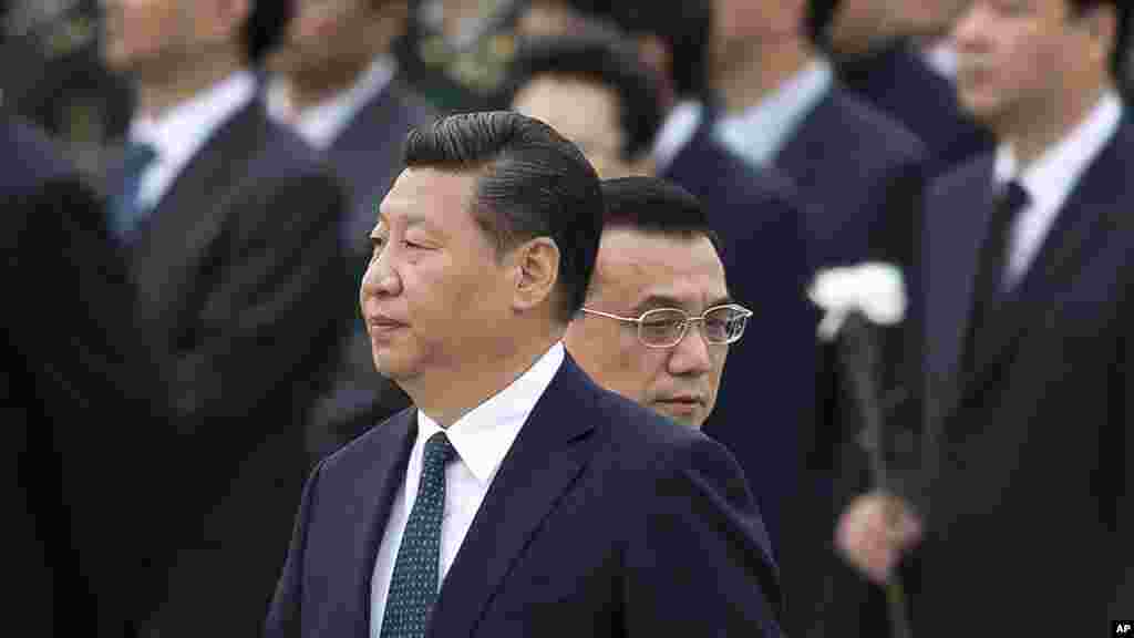 FILE - Chinese Premier Li Keqiang, right, walks past Chinese President Xi Jinping as they arrive to the Monument to the People's Heroes during a ceremony marking Martyr’s Day at Tiananmen Square in Beijing, China, Sept. 30, 2014. 