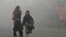 Pedestrians walk along a road engulfed in thick smog in Lahore, Pakistan, Nov. 11, 2024.