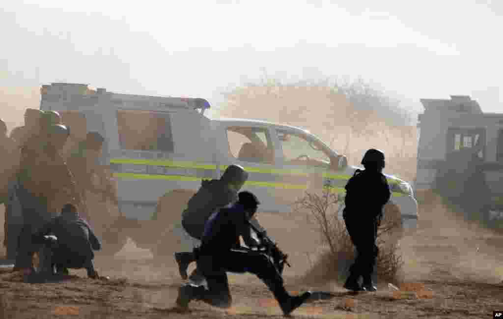 Policemen in teargas and dust open fire on striking miners at the Lonmin Platinum Mine near Rustenburg, South Africa, August 16, 2012. 