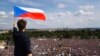 FILE - A man waves the Czech flag as people protest in Prague, Czech Republic, June 23, 2019, calling on Prime Minister Andrej Babis to step down over fraud allegations.