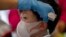 A health worker checks the temperature of tourist from Wuhan, China, as he waits for a charter flight back to Wuhan at the Suvarnabhumi airport, Bangkok, Thailand, Jan. 31, 2020.