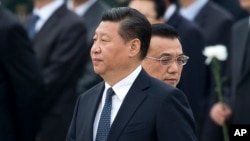 FILE - Chinese Premier Li Keqiang, right, walks past Chinese President Xi Jinping as they arrive to the Monument to the People's Heroes during a ceremony marking Martyr’s Day at Tiananmen Square in Beijing, Sept. 30, 2014. 