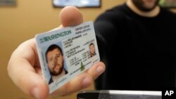На фото: Чоловік із штату Вашингтон демонструє водійські права. Зміни описані у матеріалі торкнулися штату Міннесота