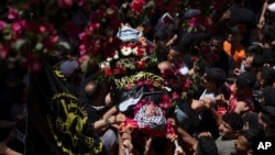 Dolientes cargan el cuerpo del joven palestino Saleh Sabra, de 22 años, quien pereció en un choque con soldados israelíes en Naplusa, Cisjordania, el 15 de mayo de 2023.
