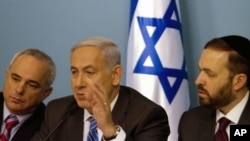 Israel's Prime Minister Benjamin Netanyahu (C) speaks as he sits next to Finance Minister Yuval Steinitz (L) and Housing and Construction Minister Ariel Atias during a news conference in Jerusalem, July 26, 2011