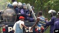 Un homme arrêté par la police congolaise qui le tire par les habits.