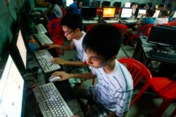 FILE - Two students use computers at an internet cafe near their dormitory in Hanoi, Vietnam, September 27, 2012. (AP Photo/Na Son Nguyen)