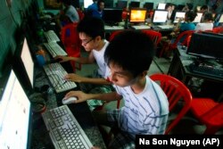 FILE - Two students use computers at an internet cafe near their dormitory in Hanoi, Vietnam, September 27, 2012. (AP Photo/Na Son Nguyen)
