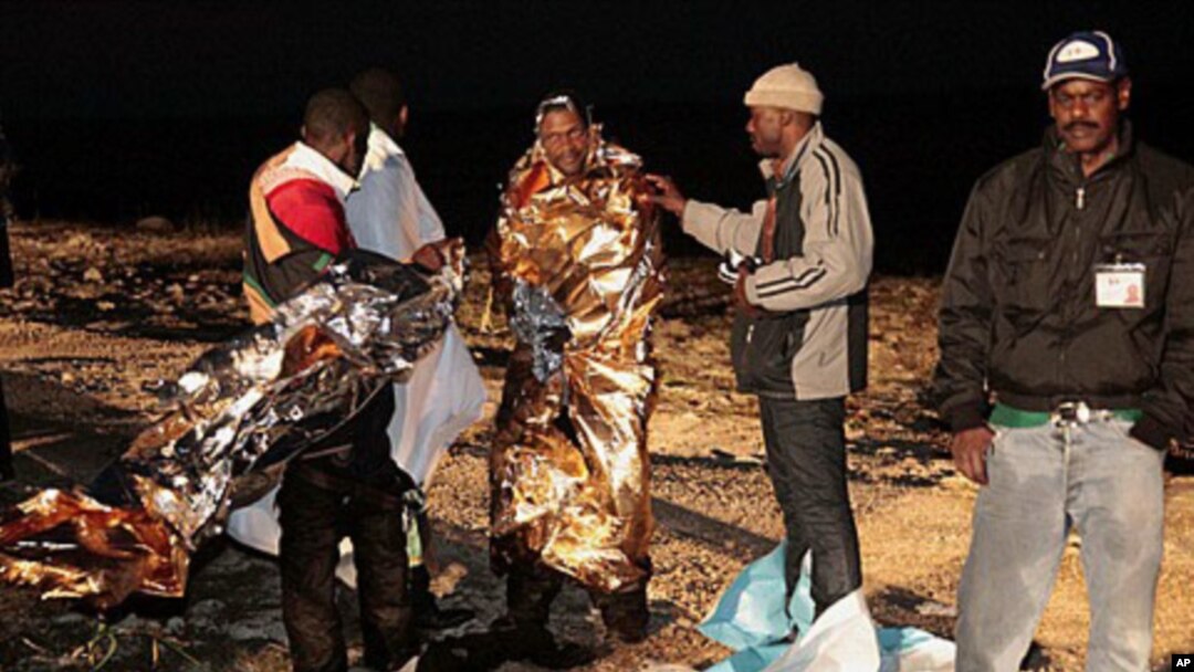 Migrants receive assistance as they arrive on the tiny island of Lampedusa, Italy, early Sunday, May 8, 2011