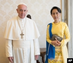 FILE - State Counsellor and Union Minister for Foreign Affairs of the Republic of the Union of Myanmar Aung San Suu Kyi poses with Pope Francis on the occasion of their private audience, at the Vatican, May 4, 2017.