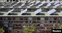 FILE - Solar panels fill the roofs of mausoleums in a cemetery in Santa Coloma de Gramanet, near Barcelona, Spain, March 28, 2011.