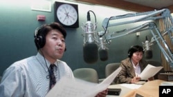 Master of ceremonies for the Voice of America's Tibetan language service Tenzin Lhundup, left, and Tseten Cho Don broadcast in the Tibetan language in the VOA studios in Washington Thursday, March 22, 2001 in Washington. (AP Photo/Joe Marquette)