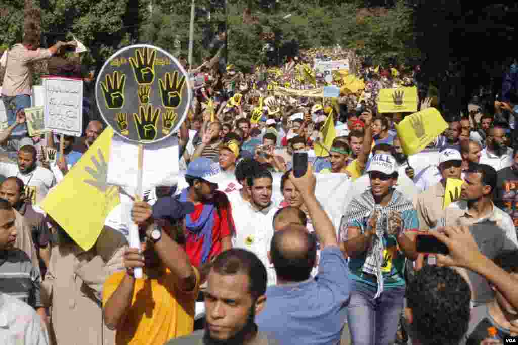 Protesters hold up four fingers as they march in Maadi, southern Cairo, Sept. 20, 2013. (Hamada Elrasam for VOA)