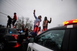 在明尼苏达州布鲁克林中心，在警察开枪打死黑人男子赖特后，示威者站在警车上抗议。(2021年4月11日)