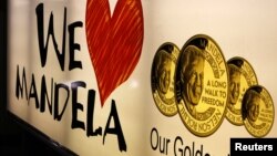 A banner advertises gold coins with the image of former South African President Nelson Mandela, Johannesburg, December 9, 2012. 