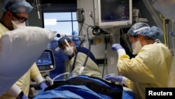 Petugas media tampak memberikan perawatan kepada pasien yang terinfeksi COVID-19 di ruangan ICU di Tumah Sakit Western Reserve di Cuyahoga Falls, Ohio, pada 4 Januari 2022. (Foto: Reuters/Shannon Stapleton)