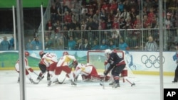 China's Goalie dives to make a save against the US team in Olympic Women's hockey in Vancouver