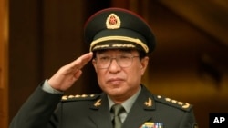 FILE - Chinese General Xu Caihou listens to national anthems during welcome ceremony at the Pentagon, Washington.