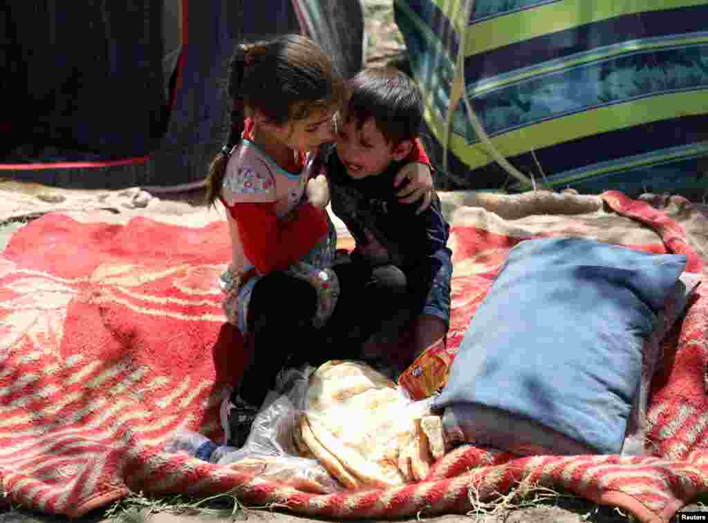 An internally displaced boy and his sister from Afghanistan&#39;s northern provinces, who fled from their home because of fighting between the Taliban and Afghan security forces, take shelter at a public park, in Kabul, Afghanistan.