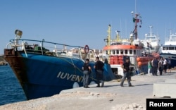 Italian police stand around the German NGO Jugend Rettet ship Iuventa in Lampedusa harbor, Italy, Aug. 2, 2017.