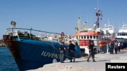 Italian police stand around the German NGO Jugend Rettet ship Iuventa in Lampedusa harbor, Italy, Aug. 2, 2017.