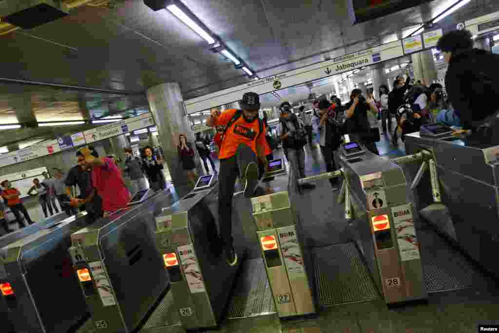 A protester jumps over closed gates inside Ana Rosa subway station during the fifth day of metro workers&#39; protest in Sao Paulo, Brazil, June 9, 2014.