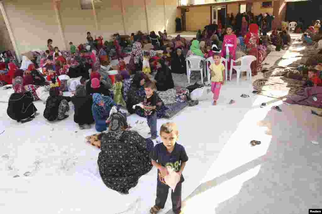 Iraqi Shi'ite Turkmen families fleeing the violence in Tal Afar arrive in Shangal, a town in Nineveh province, Iraq, June 17, 2014.