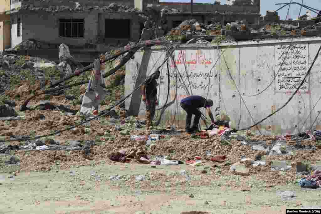 Hazzam Abdulghani, right, and his brother examine a body to see if it their 17-year-old nephew, Dhyab Idris Abdulghani, in Mosul, Iraq, June 15, 2017.