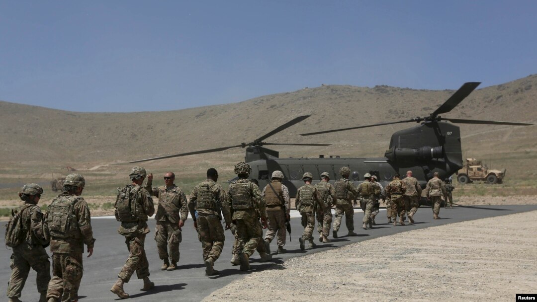 Tentara NATO berbaris memasuki helikopter Chinook menyusul upacara serah terima keamanan di akademi militer di luar Kabul (18/6). 