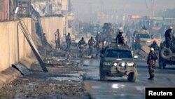 FILE - Afghan security forces inspect the site of a car bomb blast at green village in Kabul, Afghanistan January 15, 2019.