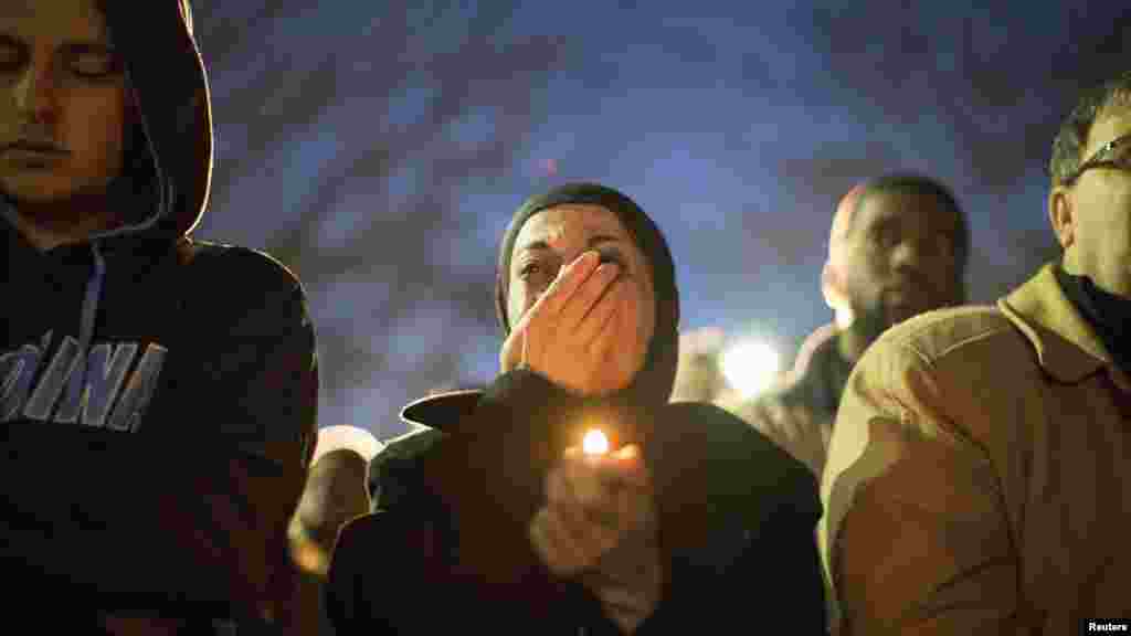 Seorang perempuan menangis saat menyaksikan penayangan video dalam acara doa bersama mengenang tiga mahasiswa muslim yang menjadi korban penembakan di kampus Universitas North Carolina di Chapel Hill (11/2).