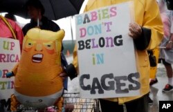 Protesters hold an inflatable doll outside of the Homestead Temporary Shelter for Unaccompanied Children, June 16, 2019, in Homestead, Fla. A coalition of religious groups and immigrant advocates said they want the Homestead detention center closed.